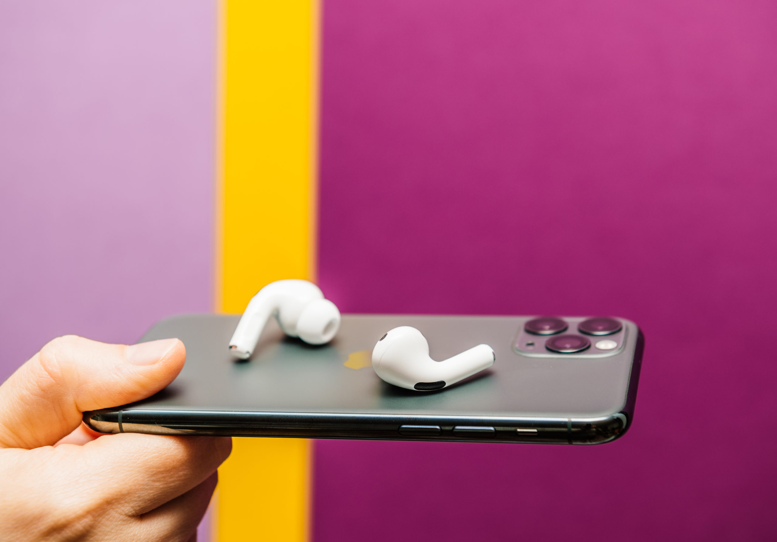 Holding iPhone with AirPods Pro (From: ©adrianhancu/123RF.COM)